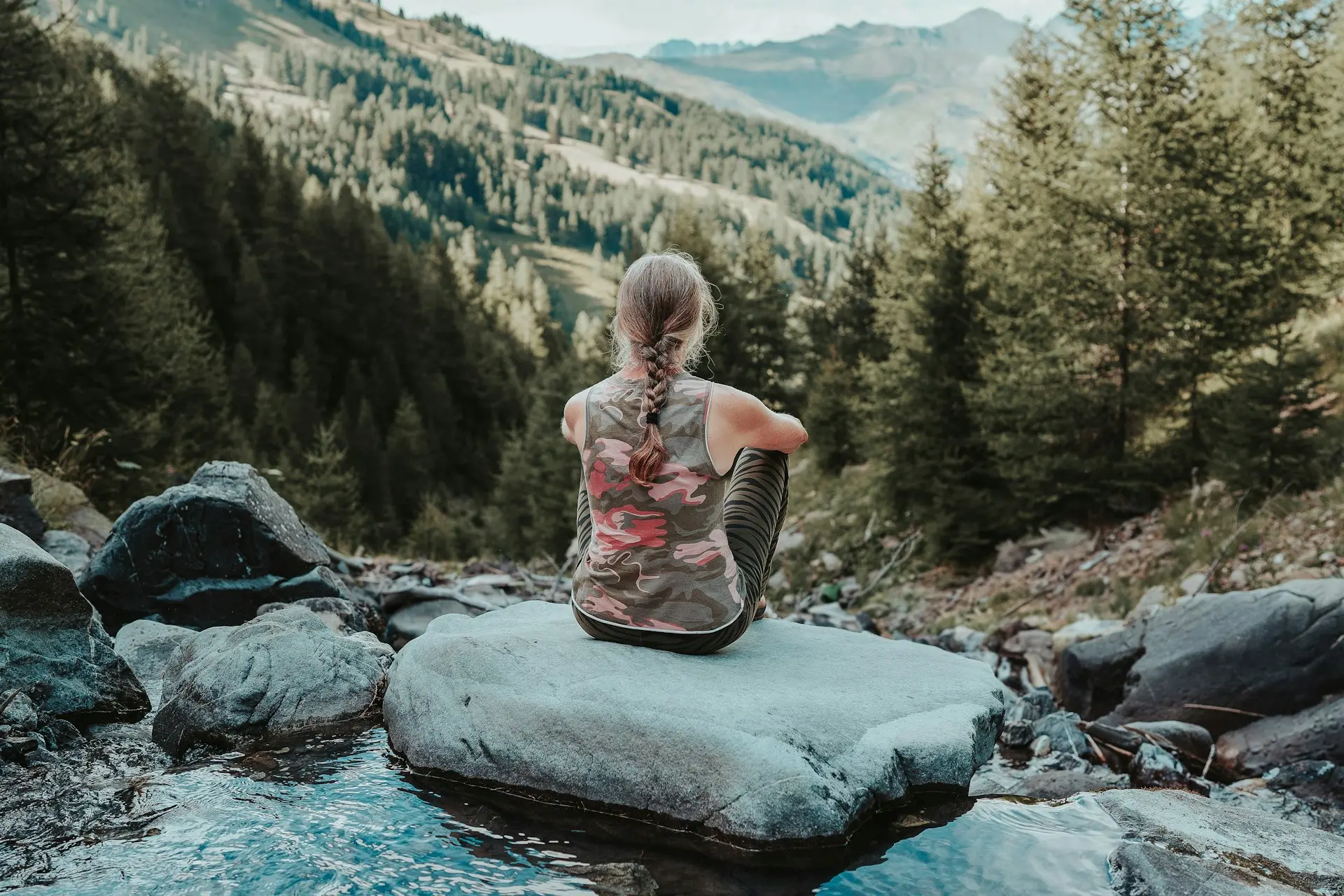 Persona sentada en la naturaleza reflexionando sobre qué hacer con su vida.